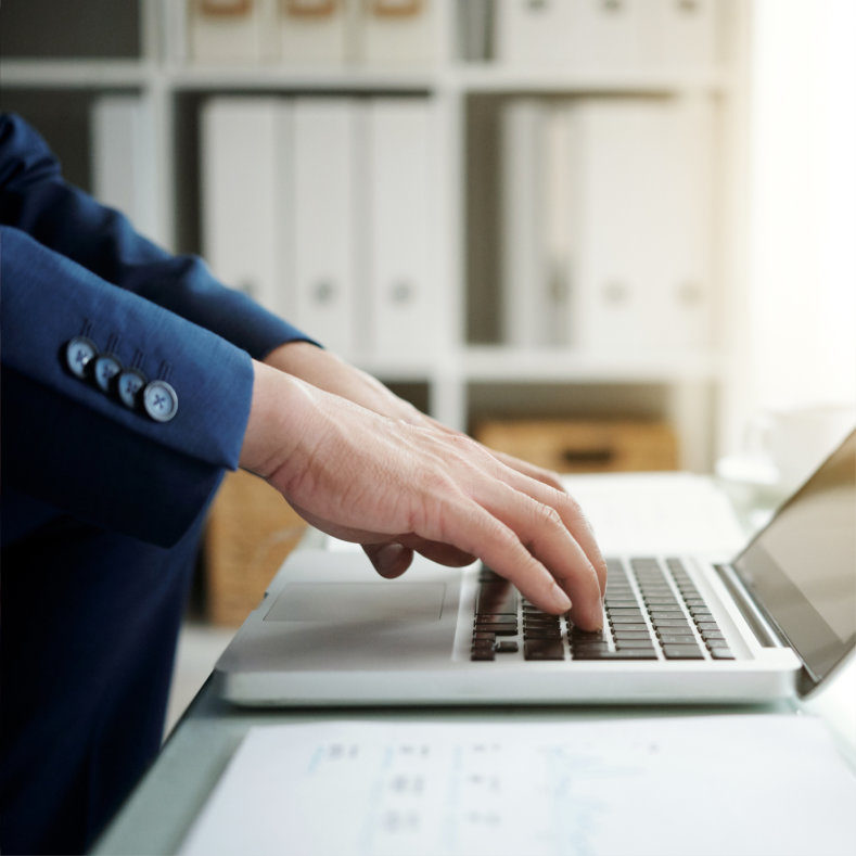 Hands of business executive working on laptop in his office